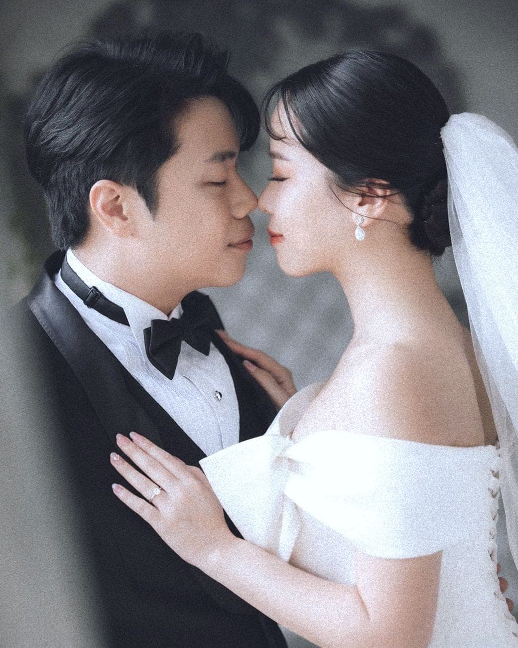Witita and Sorratat, forehead to forehead in tuxedo and gown