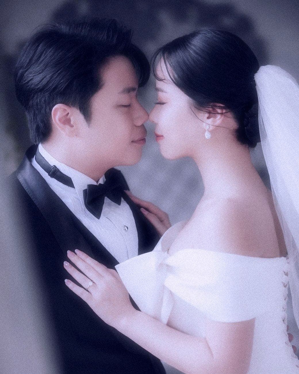 Witita and Sorratat, forehead to forehead in tuxedo and gown