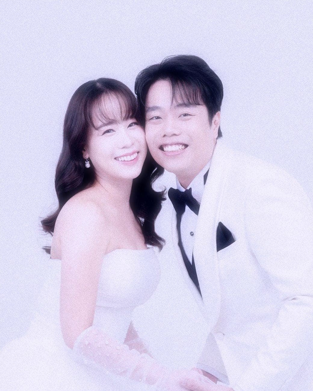 Witita and Sorratat cheek to cheek in white tuxedo and gown
