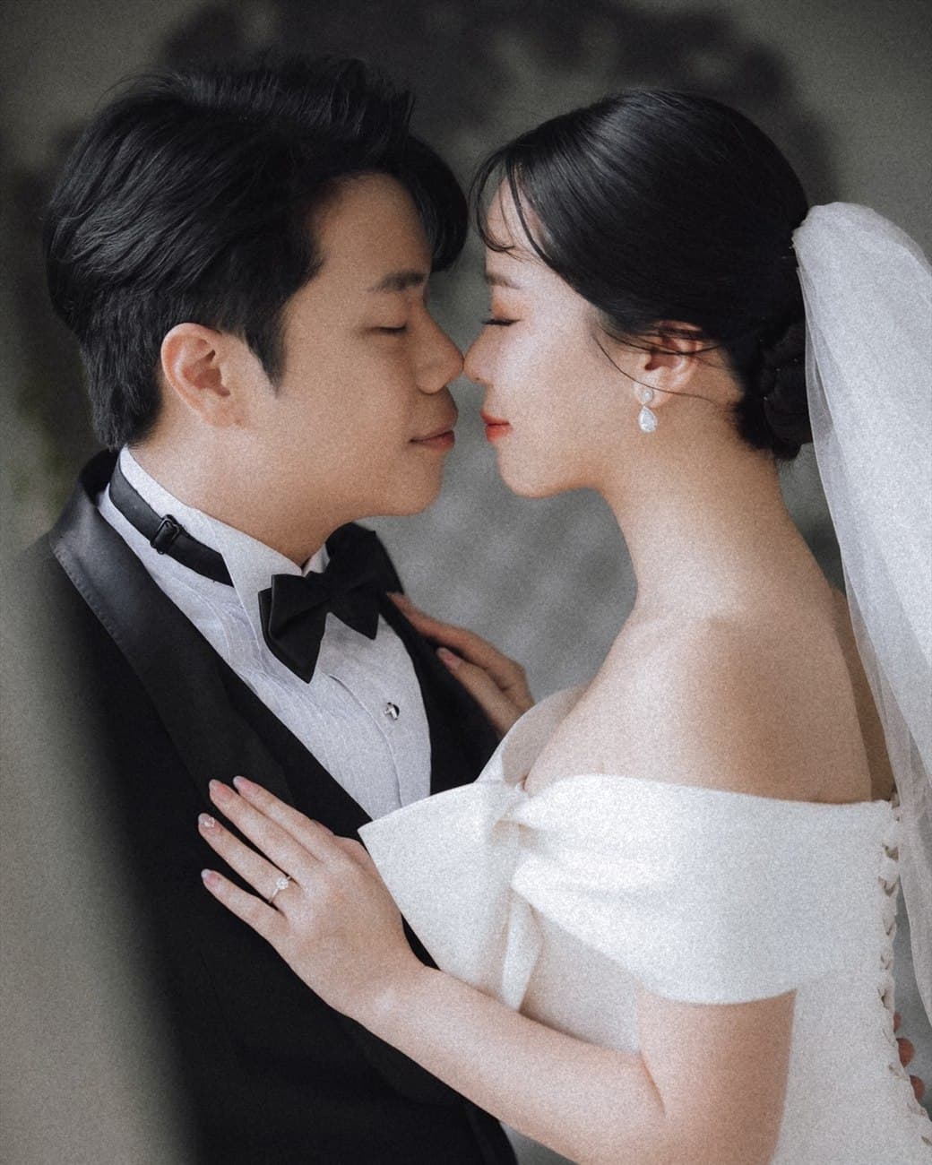 Witita and Sorratat, forehead to forehead in tuxedo and gown