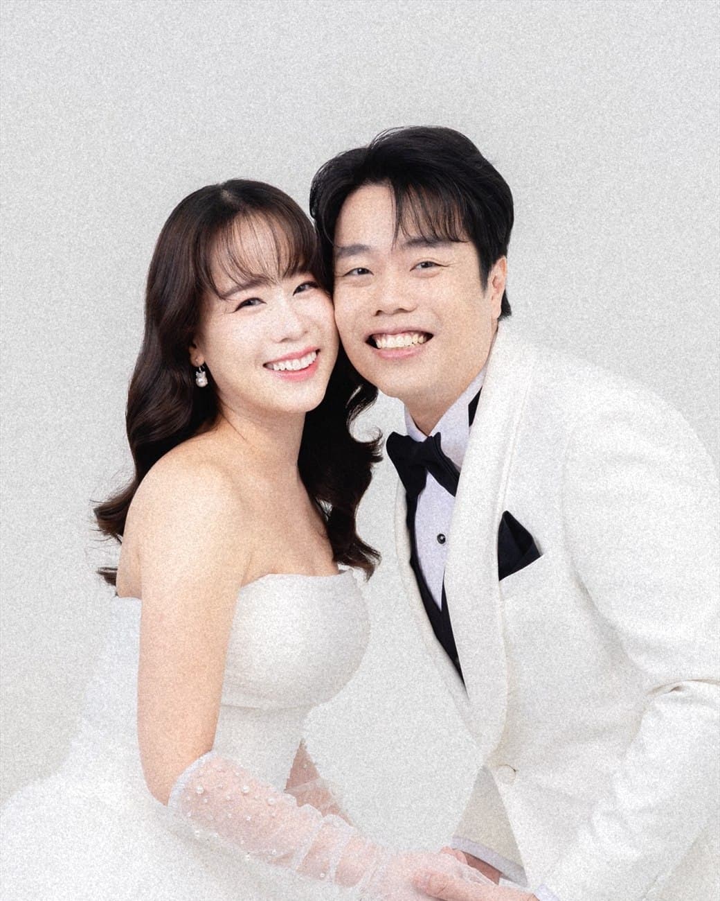 Witita and Sorratat cheek to cheek in white tuxedo and gown