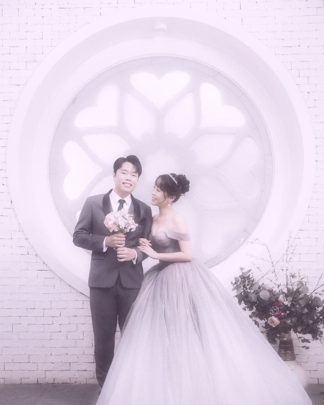 Witita and Sorratat before the rose window, Sorratat holding a small bouquet
