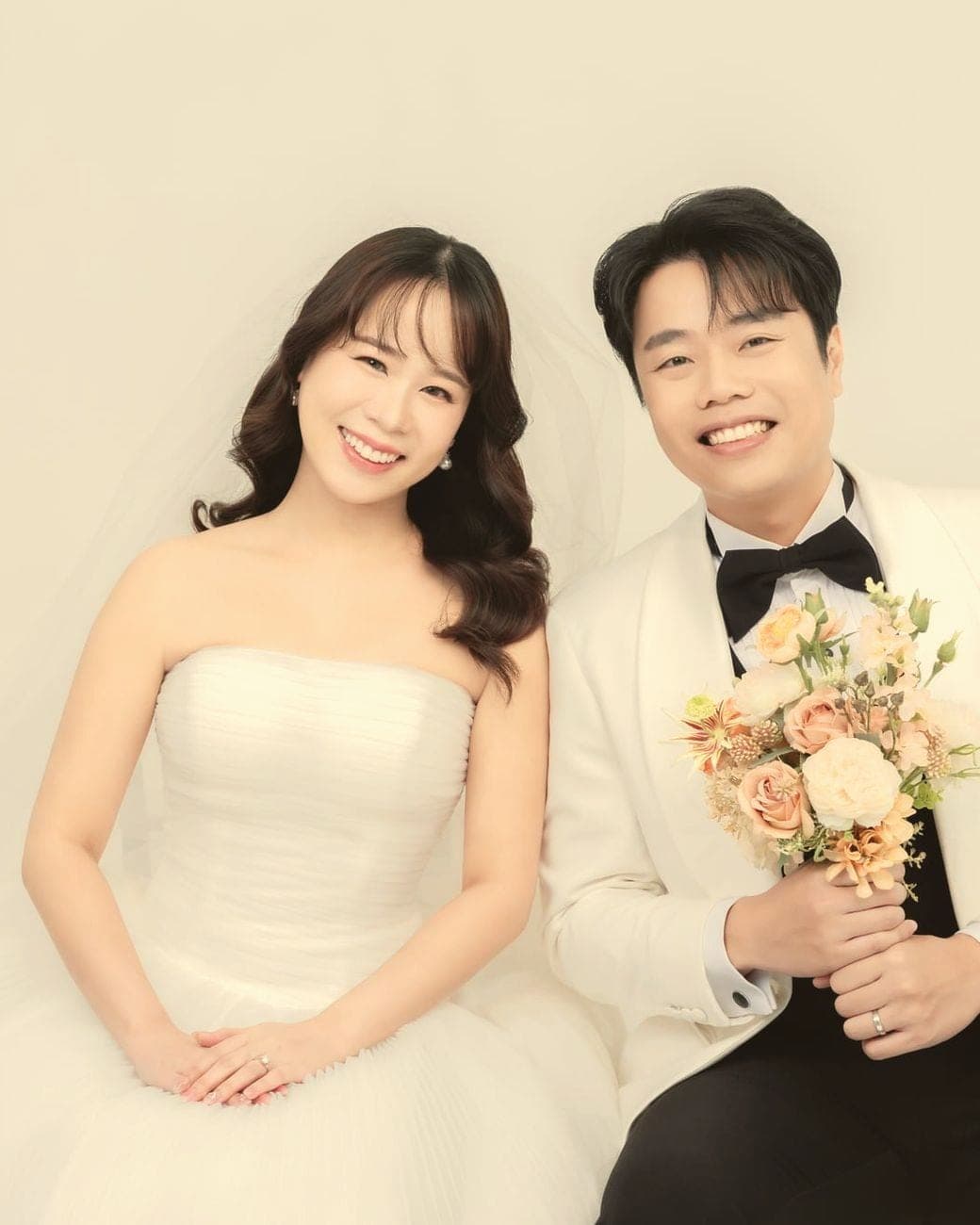 Witita and Sorratat sitting close, Sorratat holding the bouquet