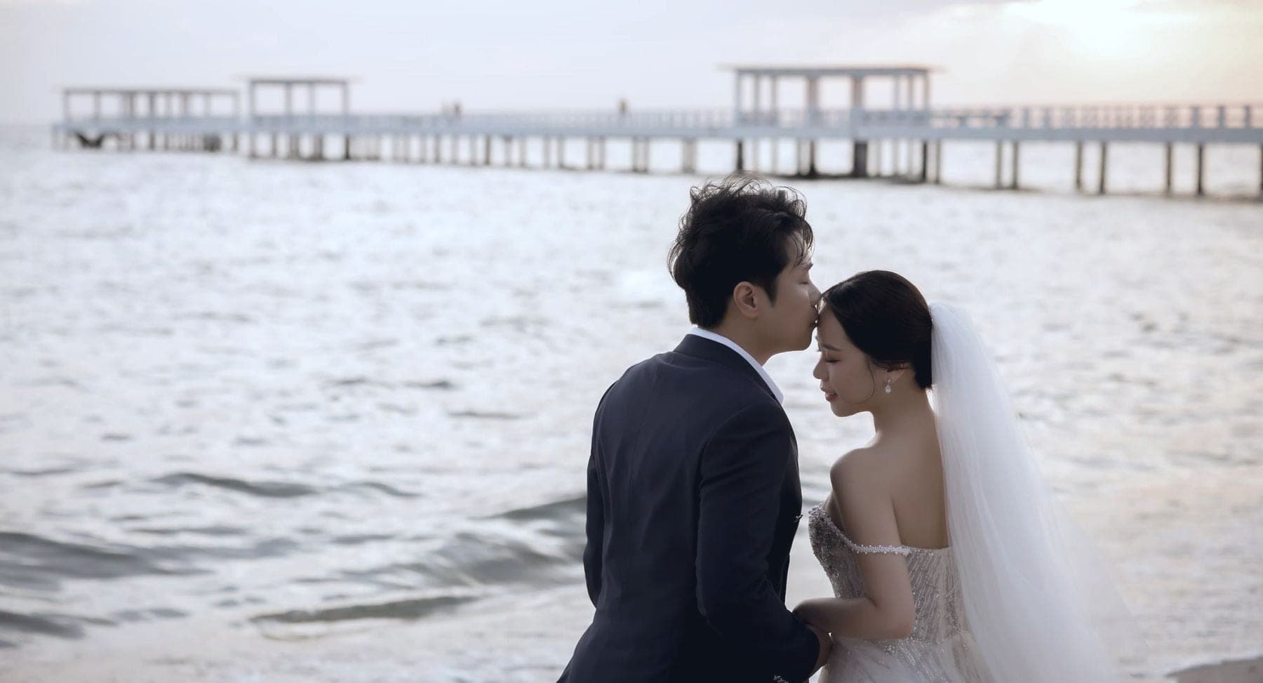 Witita and Sorratat forehead to forehead by the sea